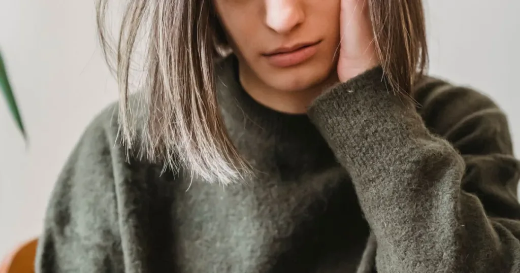 Worried woman anxiously browsing her phone at home, reflecting concern over being blacklisted or a bad credit report.