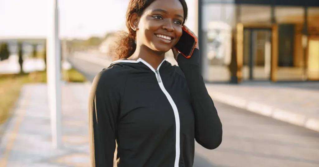 Smiling woman talking on her smartphone outdoors, representing mobile airtime and data use