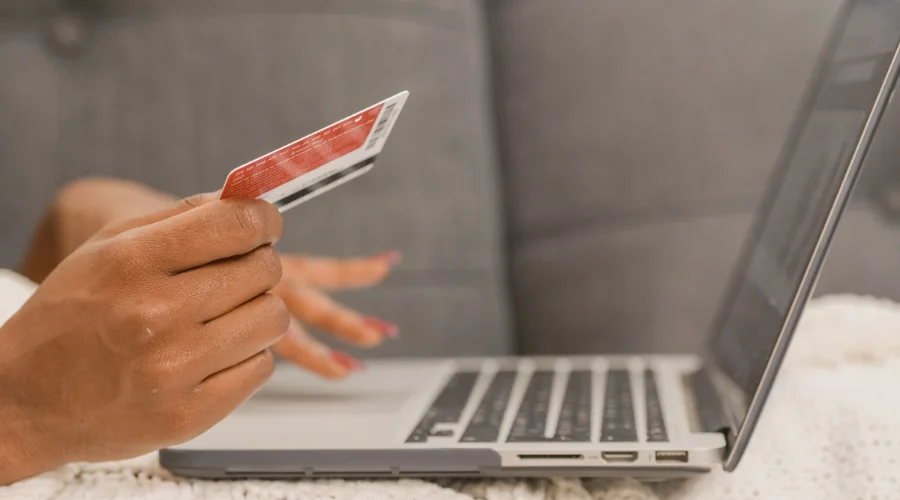 Can You Get a Credit Card If You Receive SNAP Benefits? Person holding a credit card while shopping online