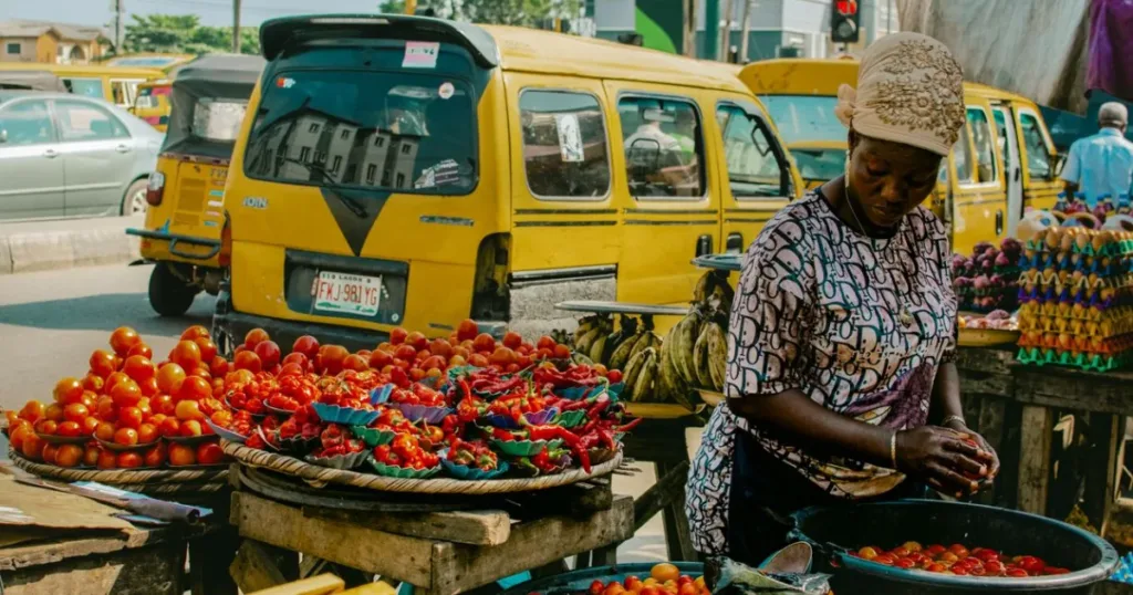 Vendor selling fresh produce at a busy street food market in Lagos, Nigeria