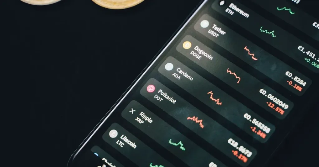 Smartphone displaying financial data and charts next to scattered coins, representing checking a credit score online.