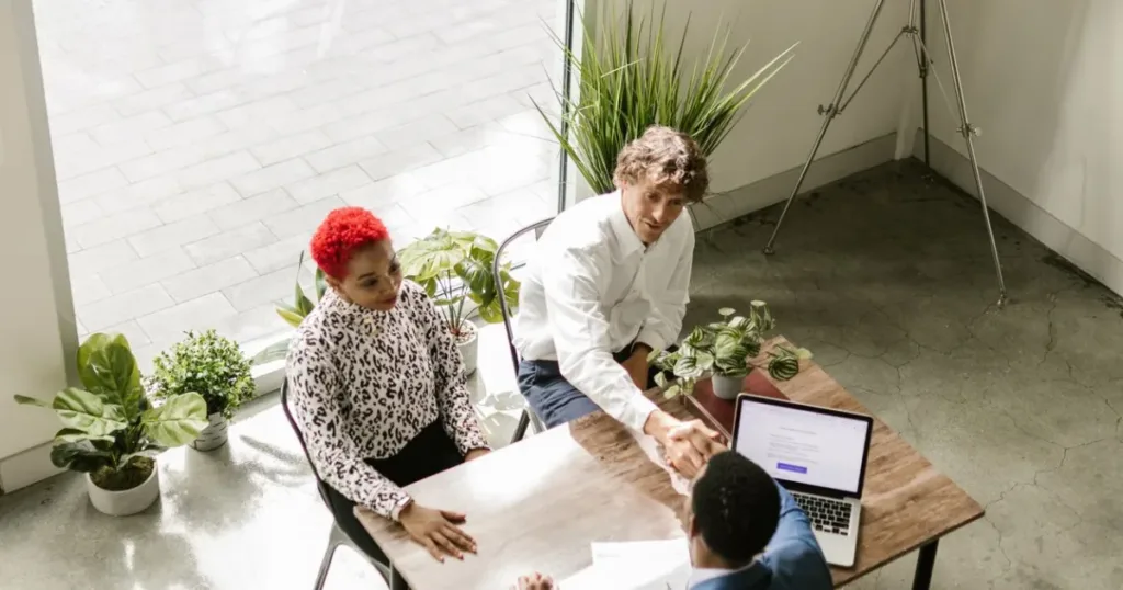 A diverse business team shaking hands after a meeting, representing trust and official approval of a loan app.