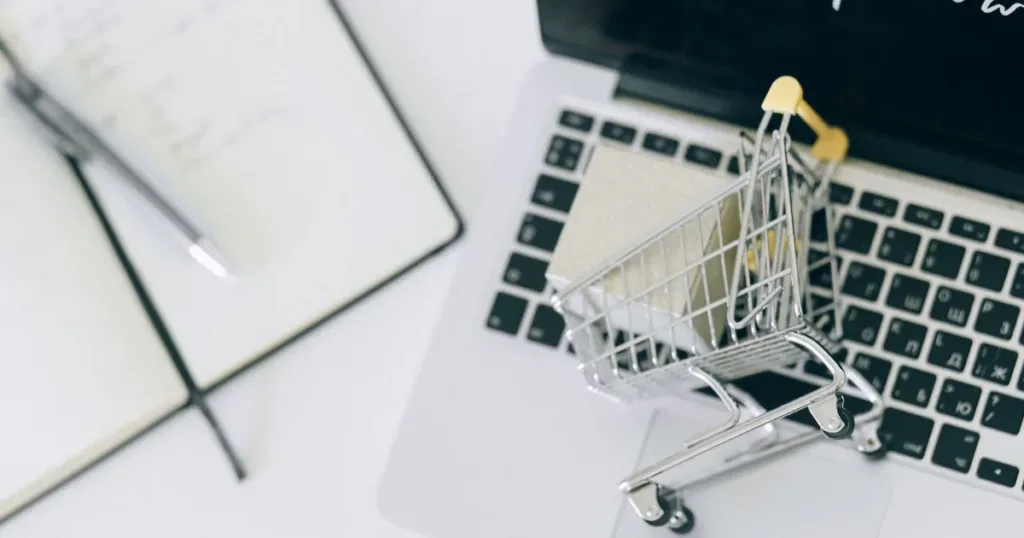 Person comparing online shopping options on a laptop with a credit card in hand