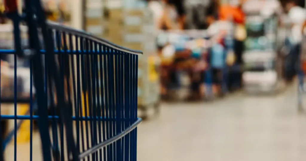 Shopper pushing a cart along a supermarket aisle