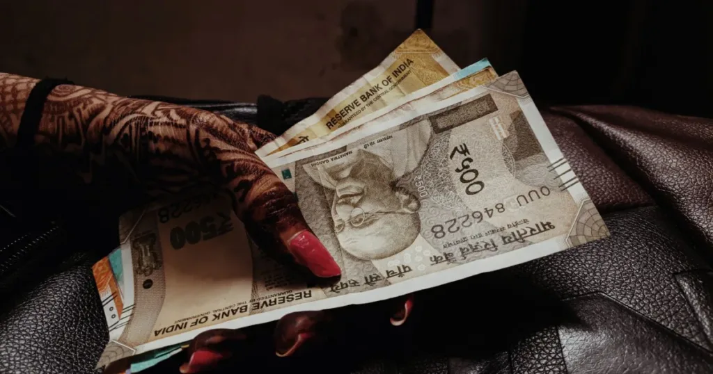 Indian woman counting rupee notes at home