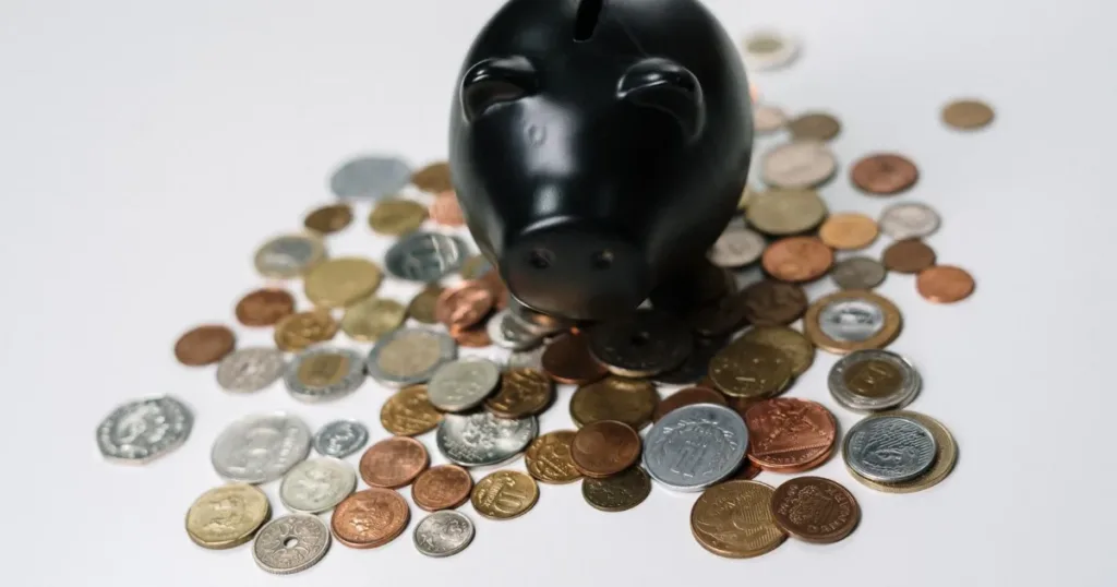 Piggy bank surrounded by coins representing the fixed deposit behind a secured credit card