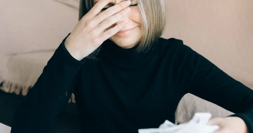 Woman reviewing overdue notices and financial paperwork