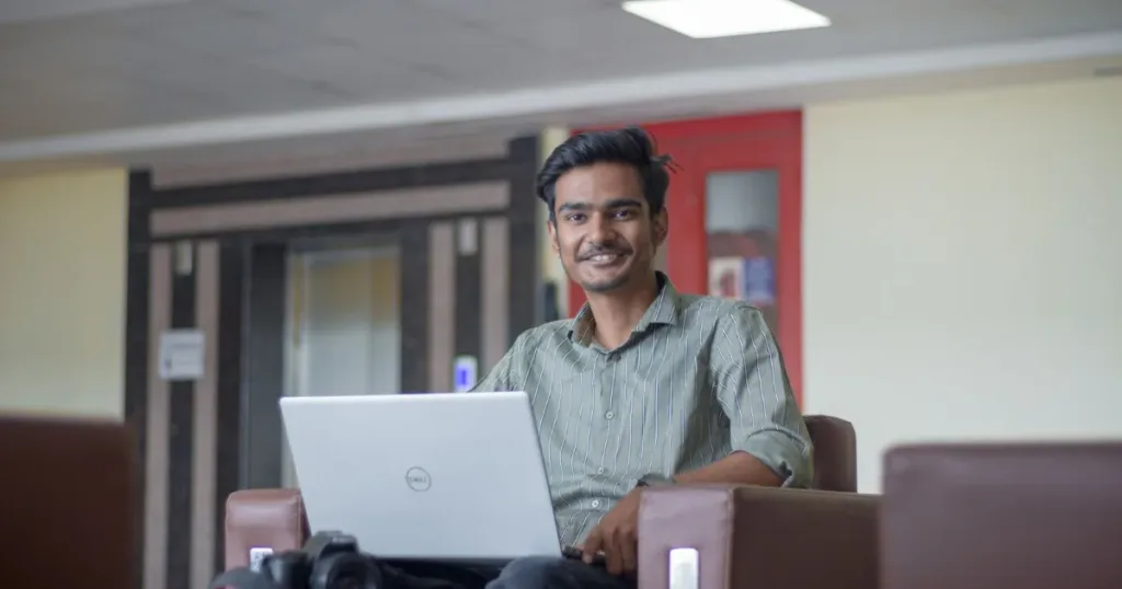 Smiling Indian freelancer working on a laptop