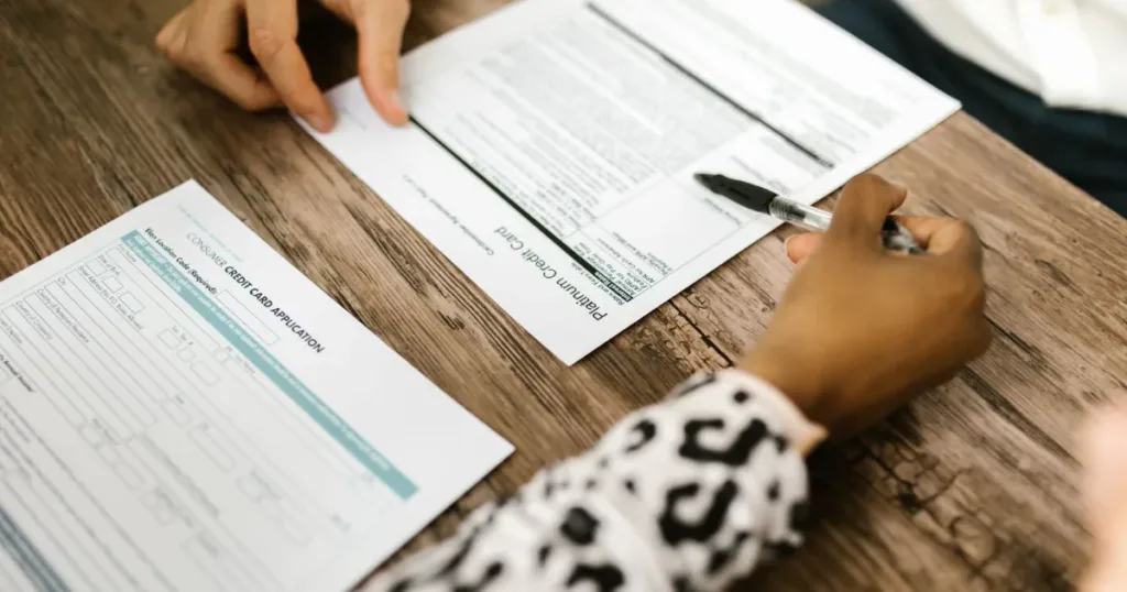 Two people reviewing and signing credit documents at a table