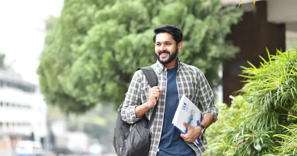 Smiling Indian college student with backpack and books