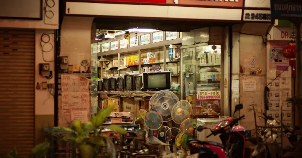 A well-lit vintage electronics store with retro TVs and fans