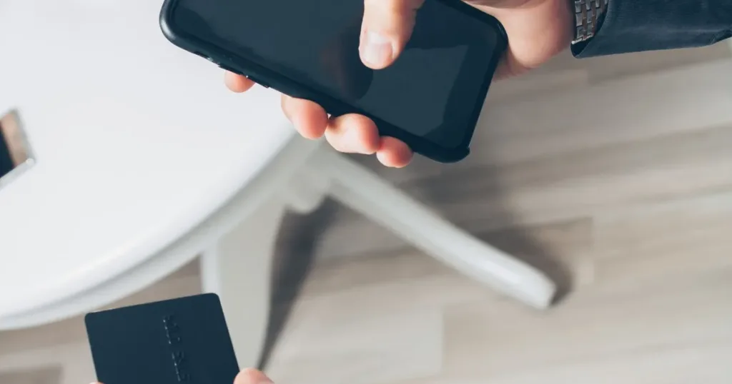 Man checking his credit card and banking app on a smartphone to track his CIBIL score