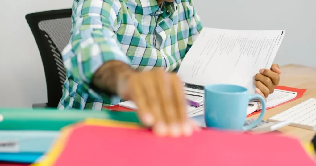 Person organizing identity documents and paperwork on a desk