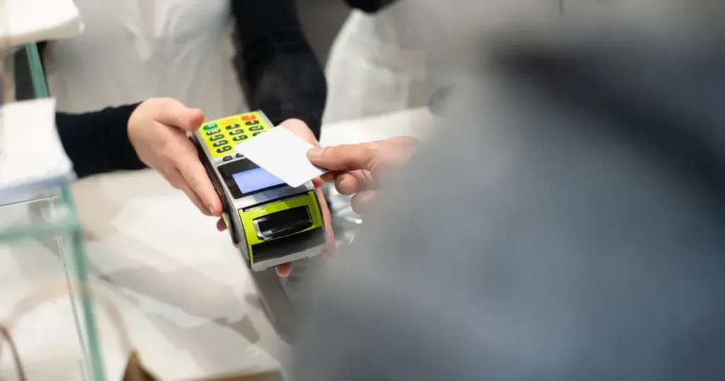 Customer paying with a card on a payment terminal at a shop counter
