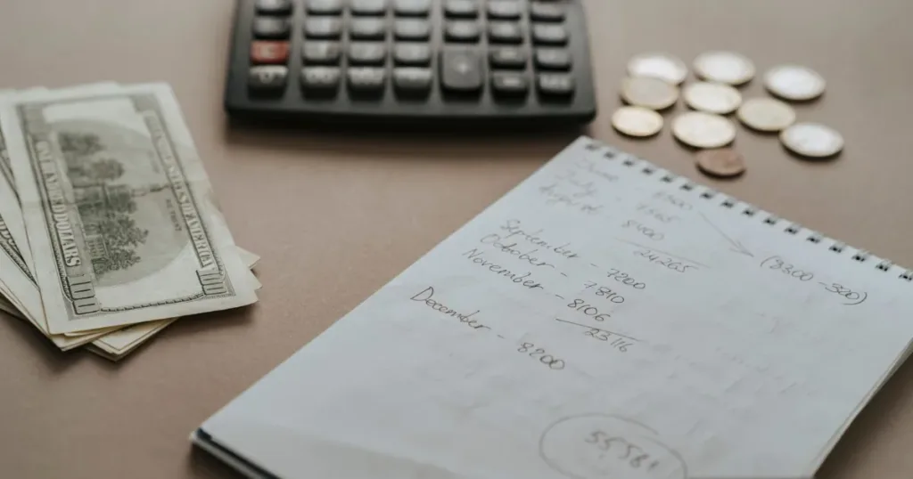 Calculator, cash and notes on a desk for planning the fixed deposit size of a secured card
