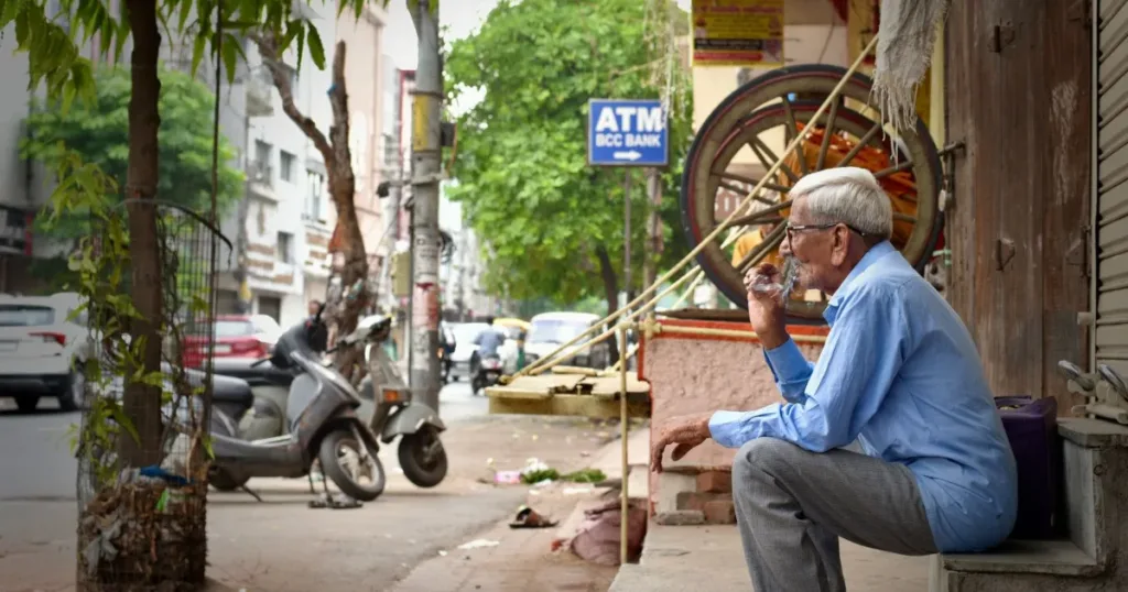 Indian man holding a RuPay debit card at an ATM