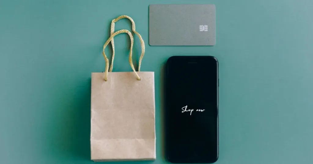 Shopper checking payment options on a smartphone with a card nearby