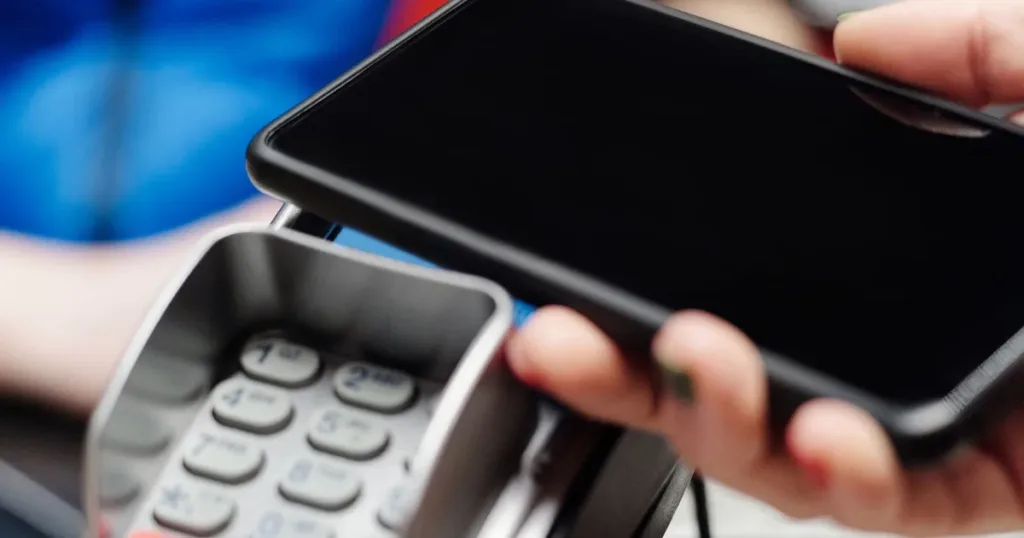 Close-up of a hand making contactless payment using a smartphone