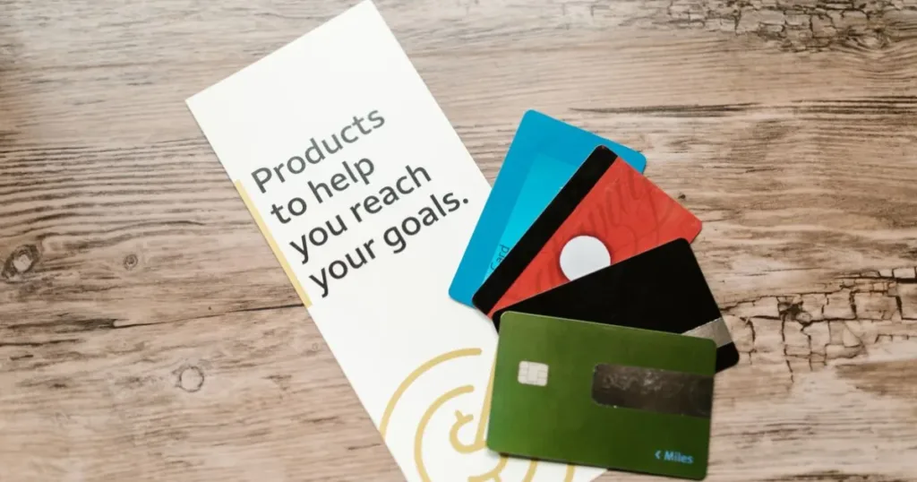 Assorted credit cards on a wooden table next to a leaflet