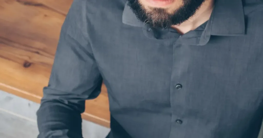 Perplexed man holding a credit card and smartphone thinking