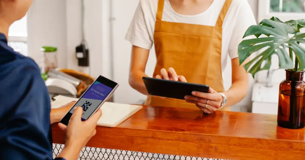 Shopkeeper accepting a QR code payment in India