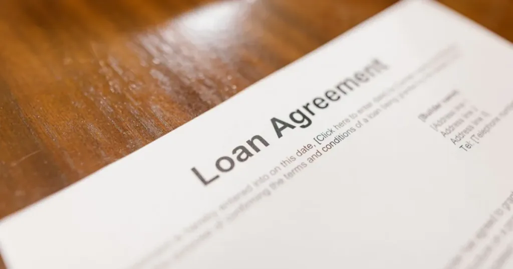 Close-up of a loan agreement document on a wooden desk