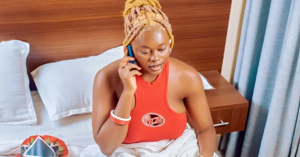 Woman relaxing at home while talking on her phone in Minna, Nigeria