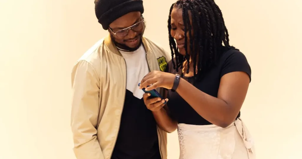 Two friends looking at a smartphone together in Lagos, Nigeria