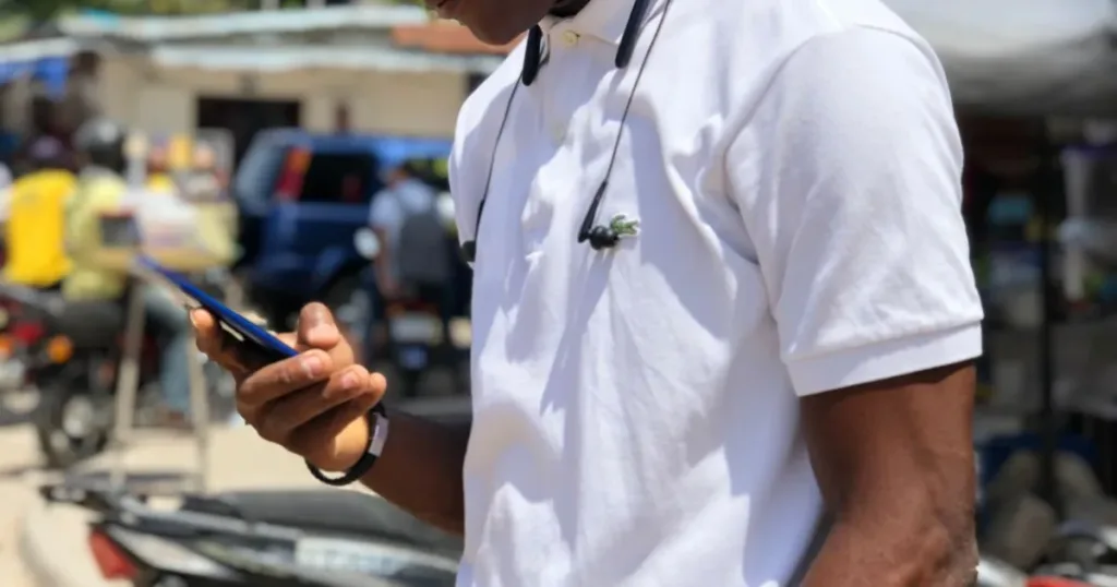 Market trader using a smartphone to receive a payment in Lagos