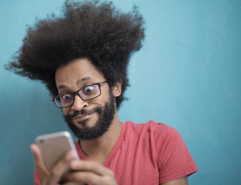 Shocked woman looking at her phone after a transaction