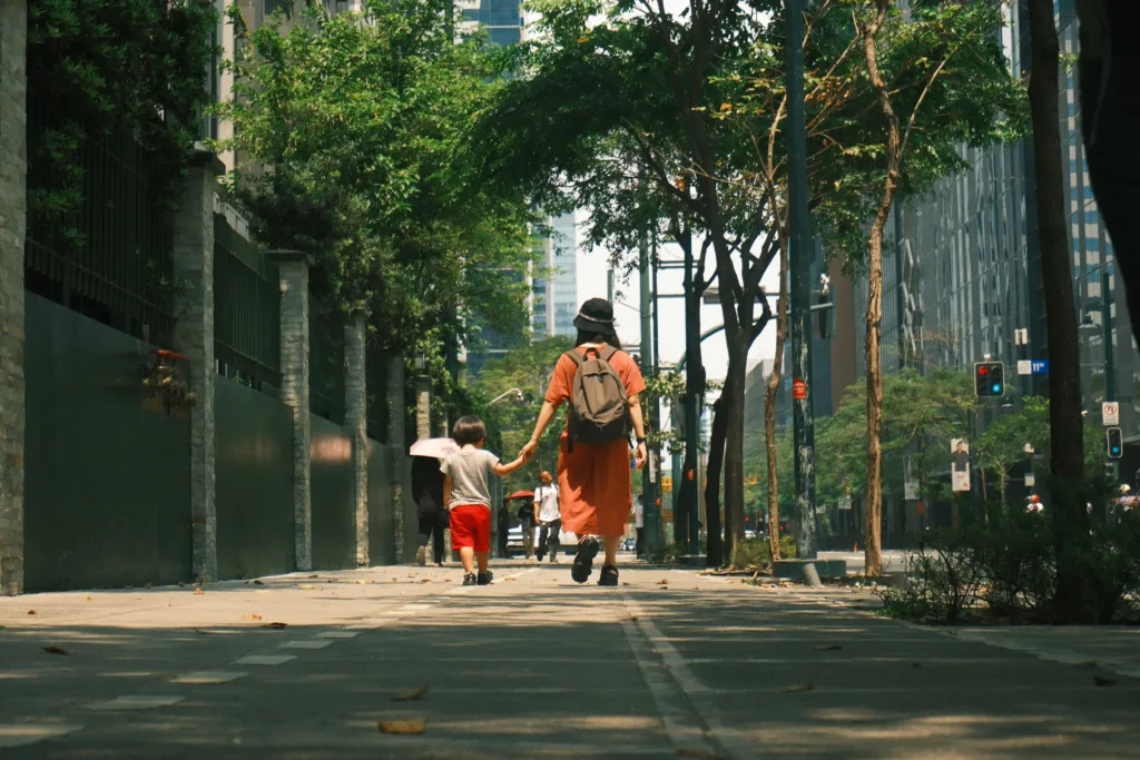 Mother and child walking hand in hand on a sunny street in the Philippines