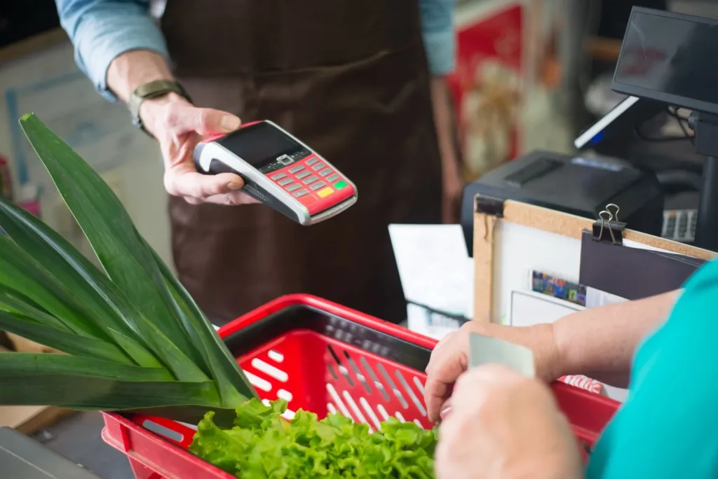 Shopper paying with a contactless card at a grocery checkout counter in the Philippines