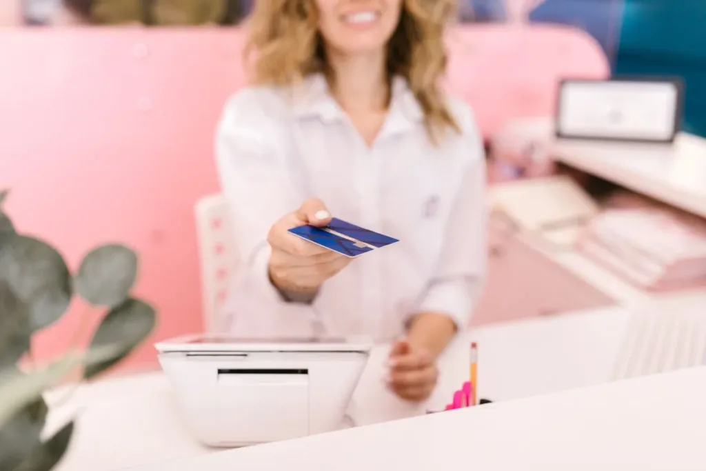 Hand holding a debit card at checkout
