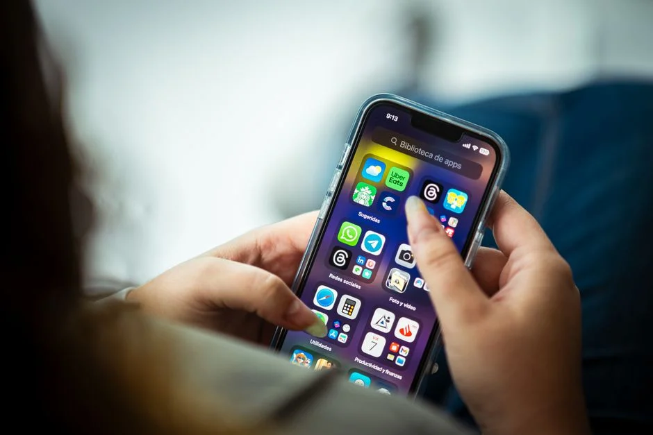 Woman comparing loan apps on her smartphone before downloading one