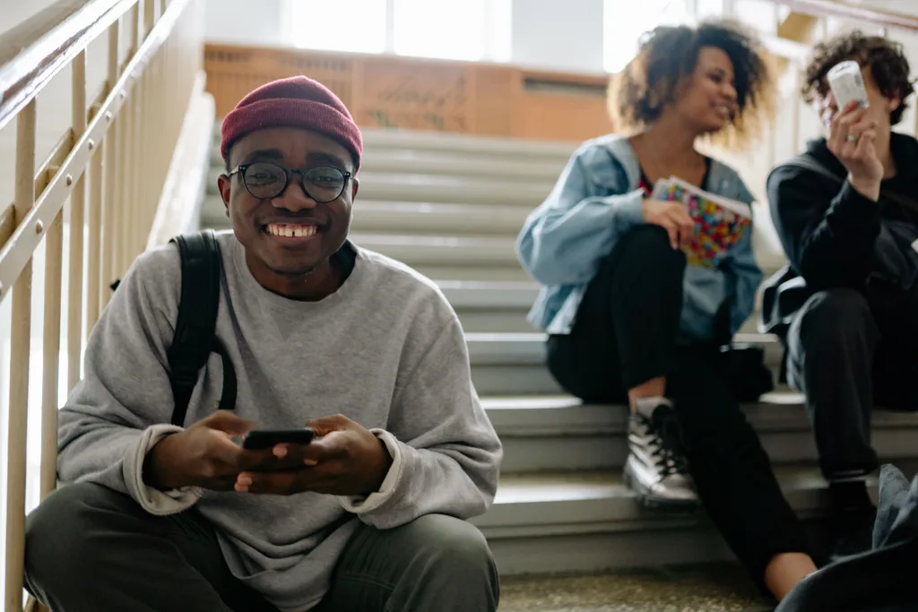 Group of students sitting together using their phones