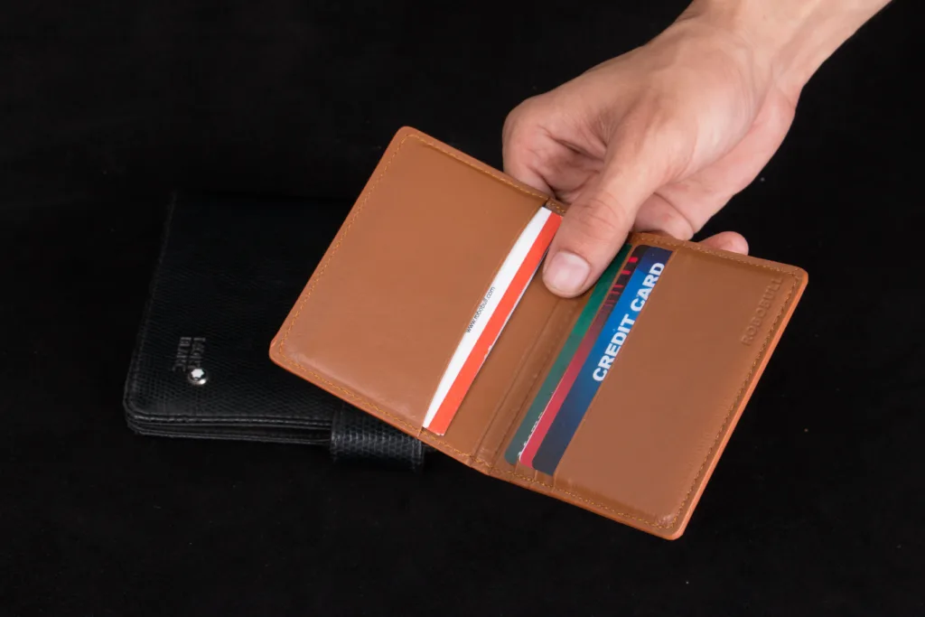 Hand holding an open wallet filled with payment cards