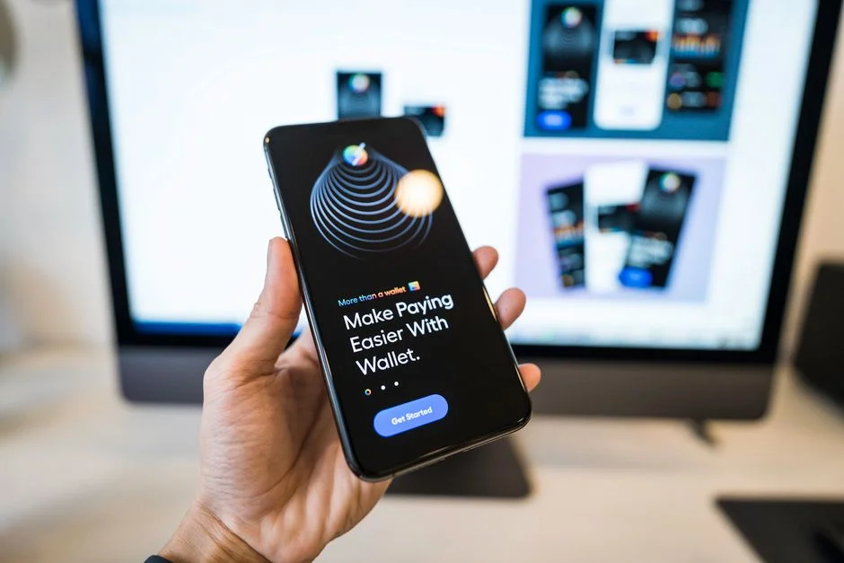 Hand holding a smartphone displaying a digital wallet app interface