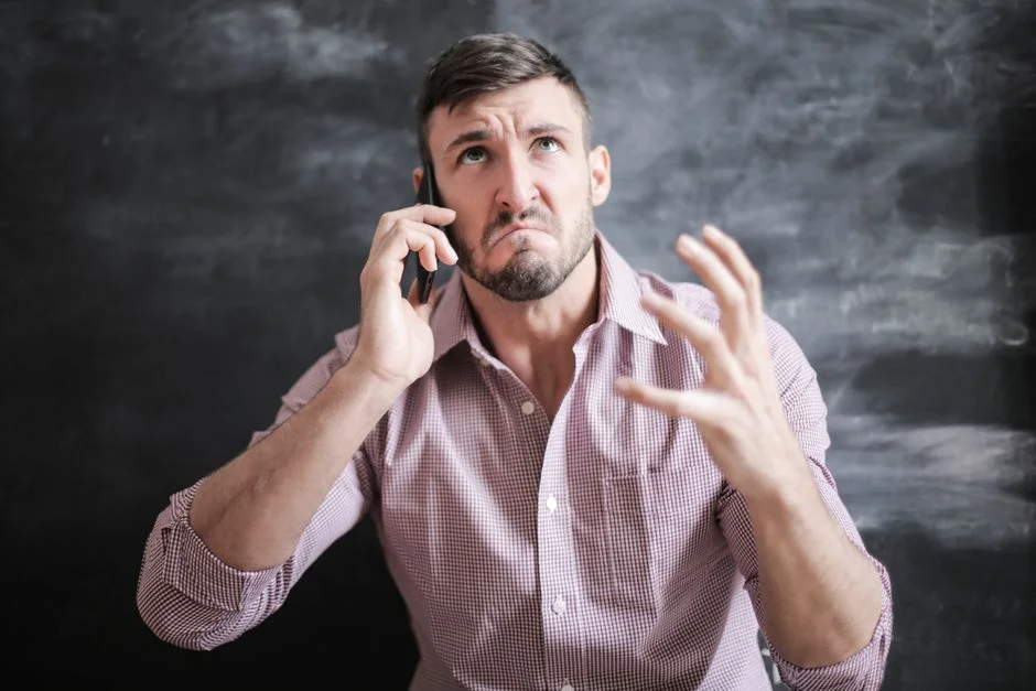 Frustrated man looking at his smartphone after a loan application issue