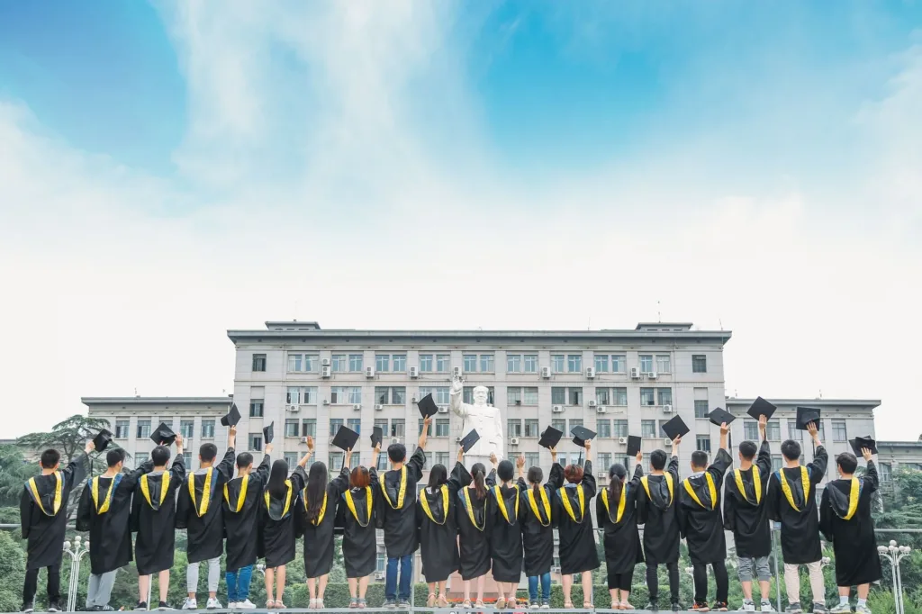 Group of graduates throwing their caps in the air outside a school building