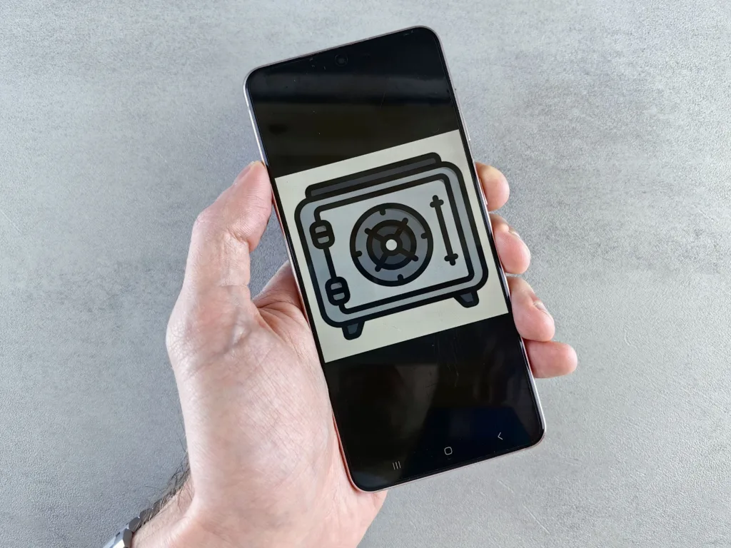 Hand holding a smartphone displaying a digital security icon