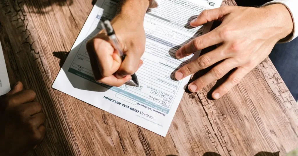 Close-up of hands filling out a loan credit application form