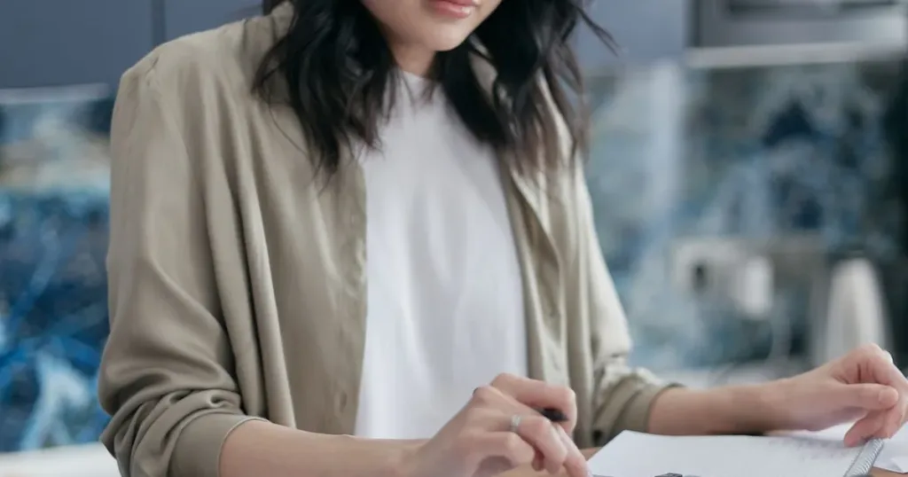 Woman calculating household bills at home to stop her salary from finishing too fast