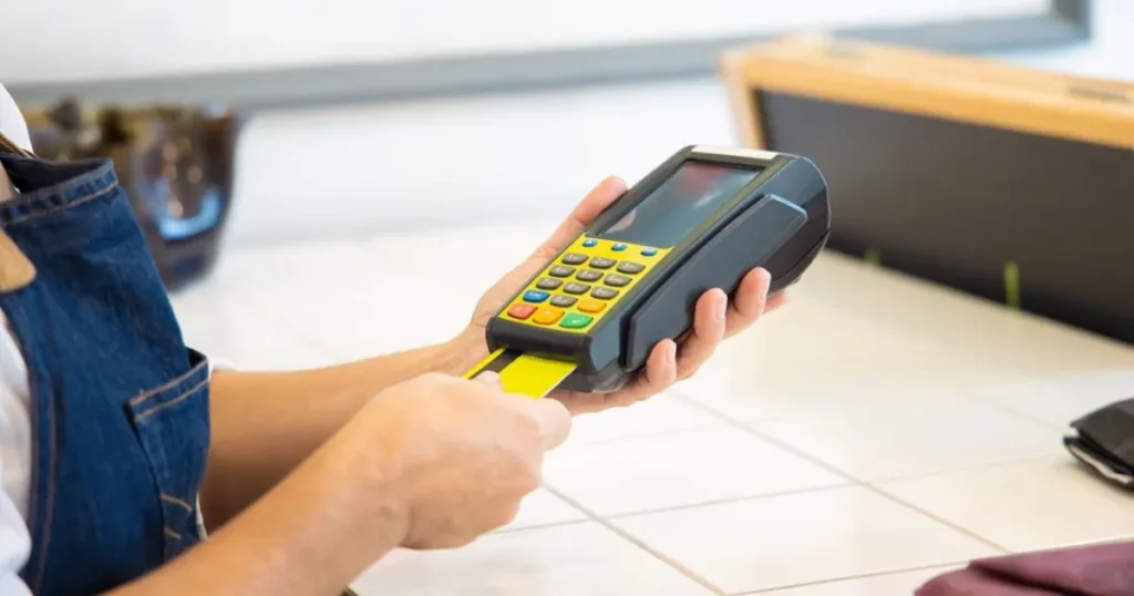 POS agent operating a card machine for a customer transaction