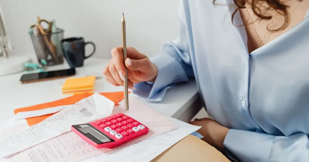 Woman using a calculator while reviewing her finances