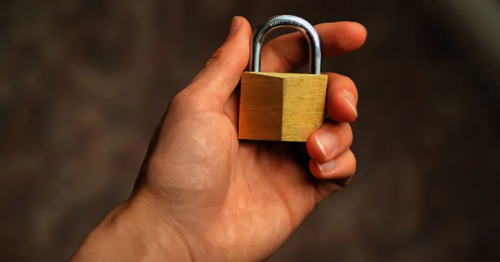Close-up of a hand holding a secure padlock representing credit protection