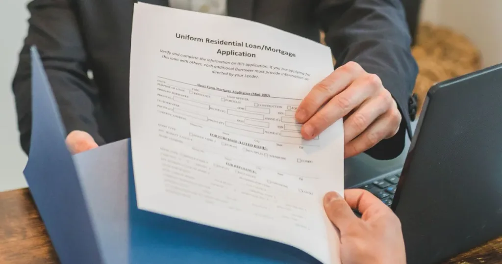 Person handing over a loan application form for review