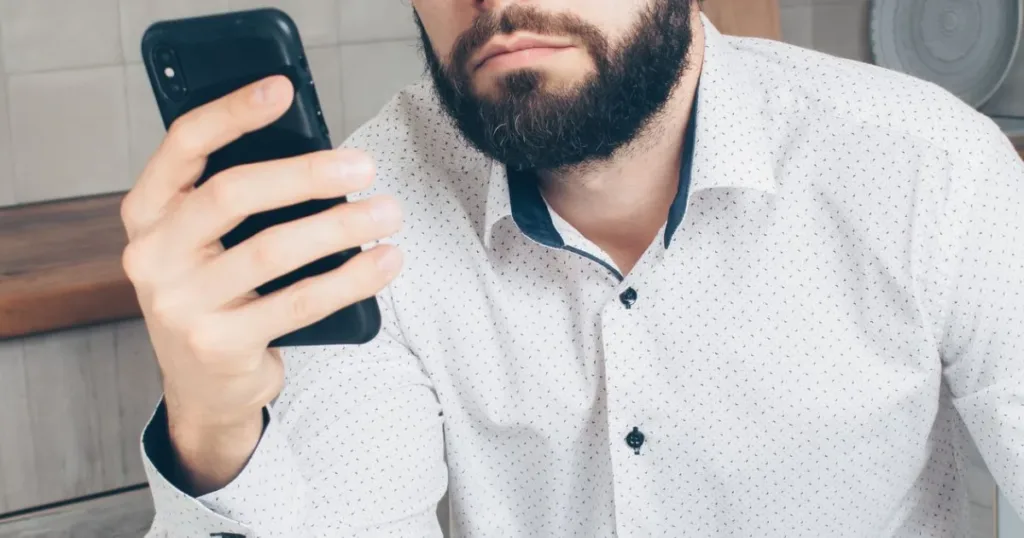 Frustrated man checking his smartphone after a failed wallet transfer