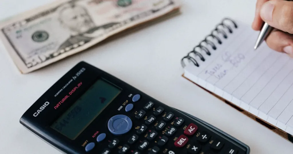 Calculator and notebook used to compare low-fee bank account fees