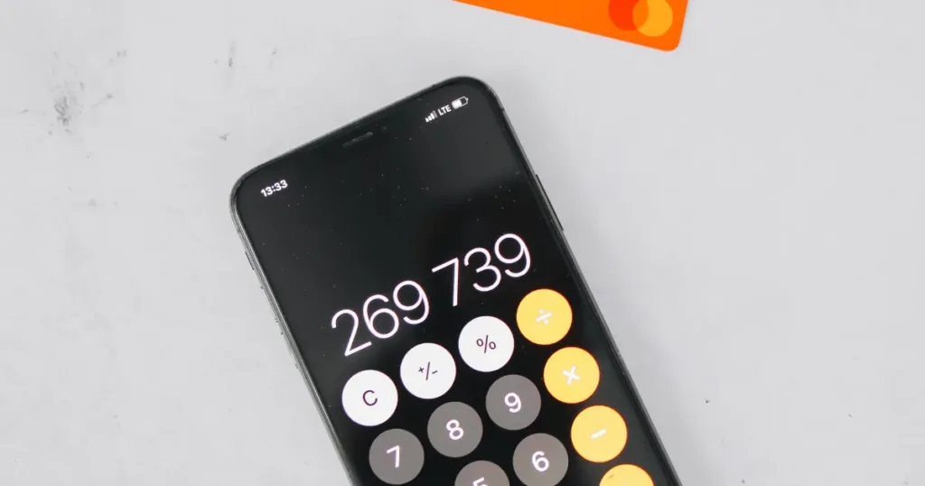 Person comparing credit card fees on a calculator and phone