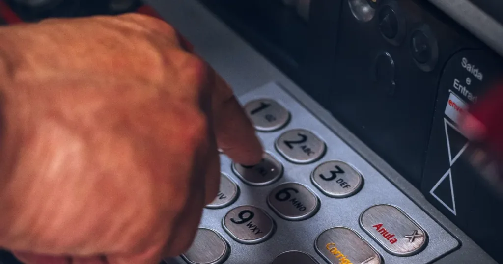 Person withdrawing cash from an ATM using a card